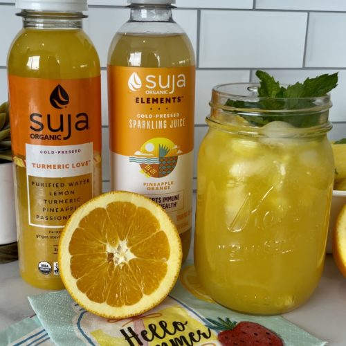 Summer Spritzer on counter with orange and Suja bottles