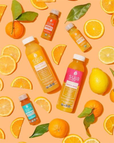 bottles of Suja juice with oranges and lemons